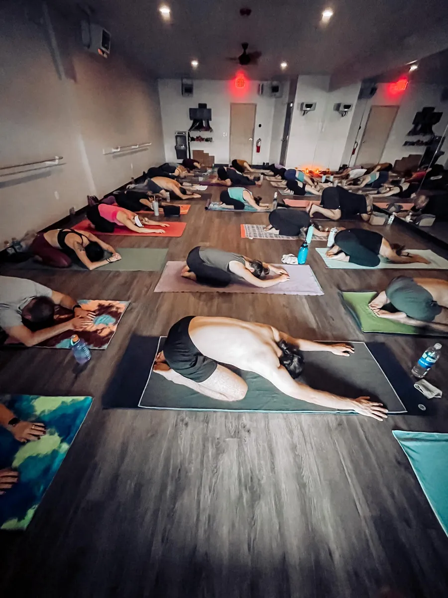 Restorative child's pose in a dimly lit hot yoga studio